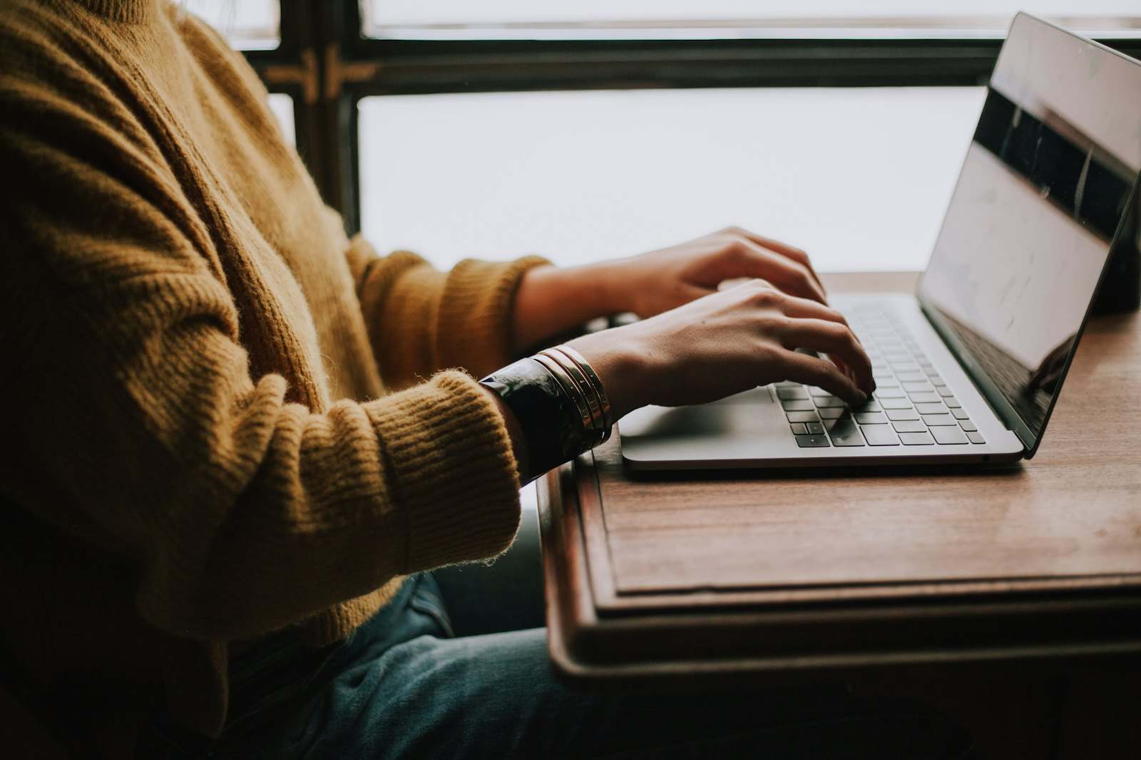 Hands on a laptop keyboard
